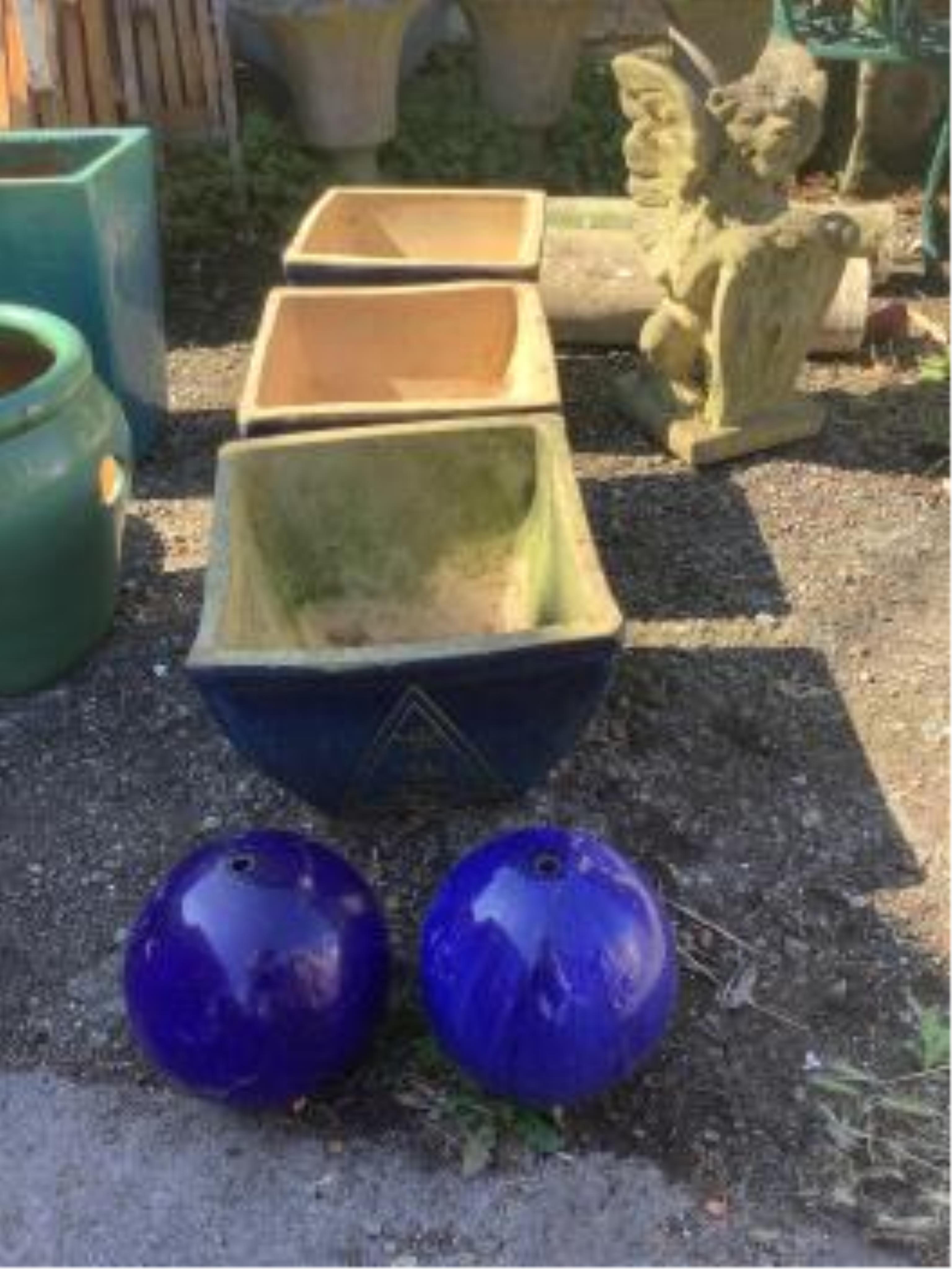 A bronzed metal stork garden ornament, a pair of terracotta lion mask wall appliqués and a pair of terracotta wall garden planters, a pair of blue glazed fountain balls and a set of three blue glazed square planters, 38c